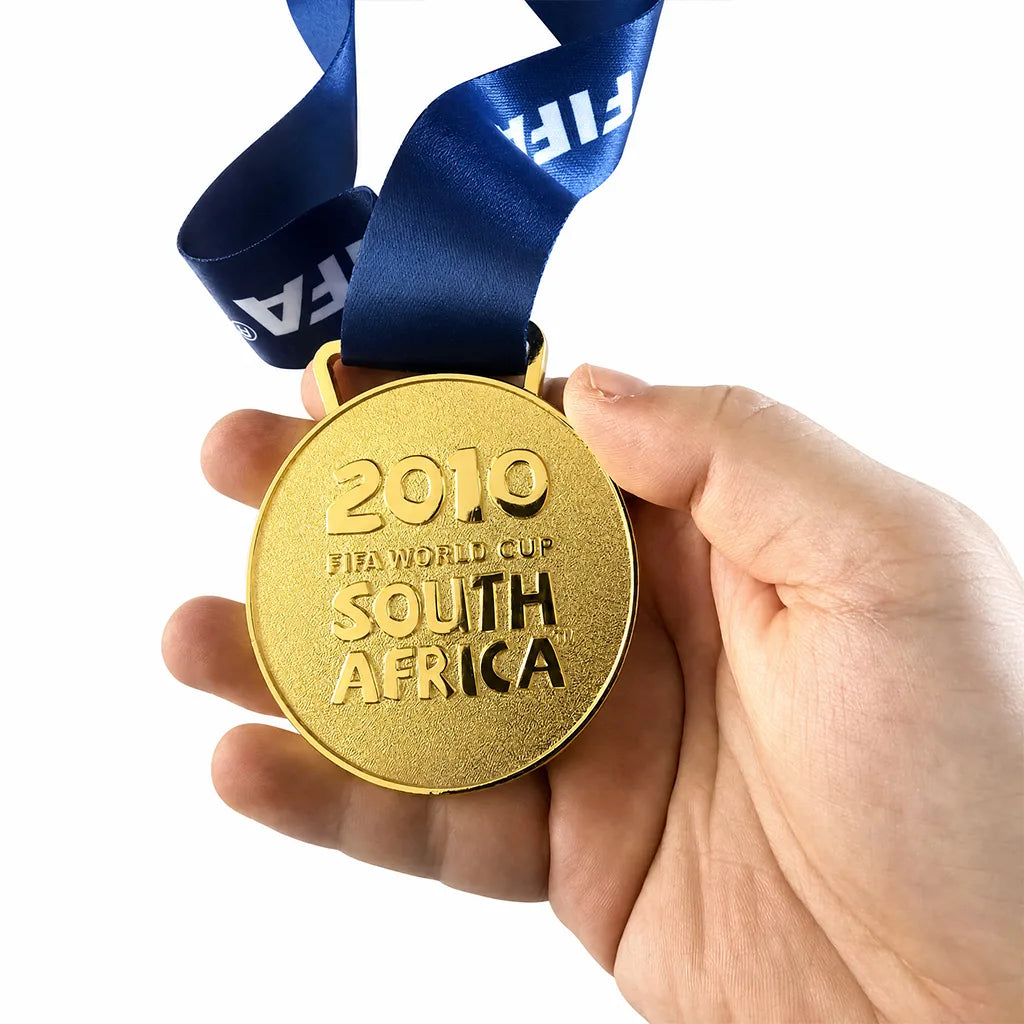 La Roja 2010 champions gold medal displayed on wooden surface