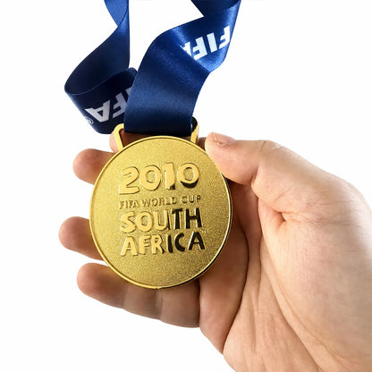 La Roja 2010 champions gold medal displayed on wooden surface